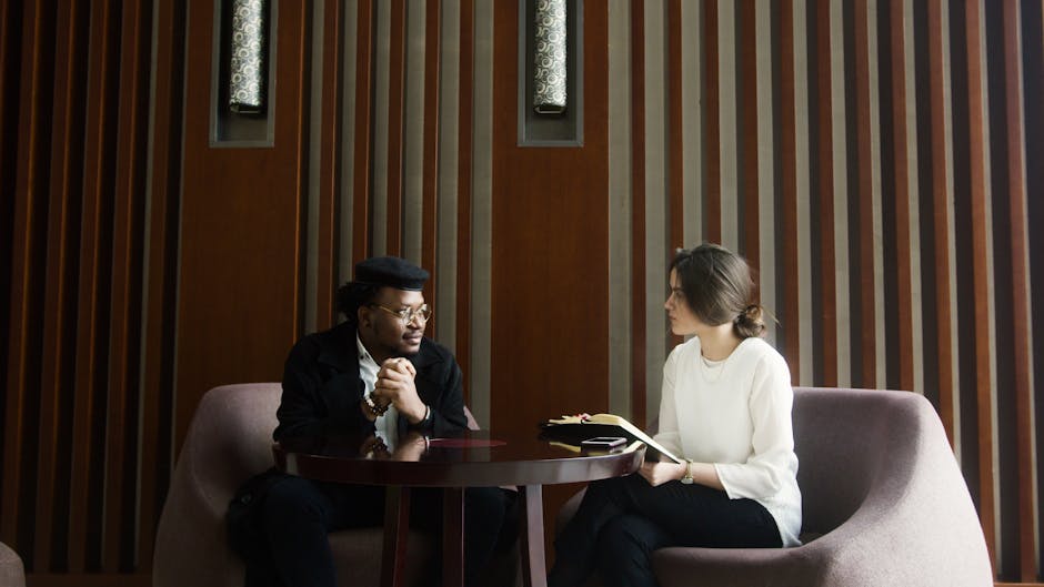A professional business meeting between a man and woman in a stylish, modern office setting.