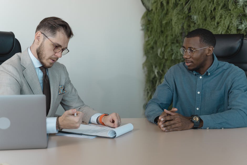 A professional job interview between two men in a modern office environment